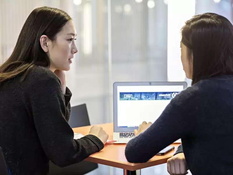 2 women students working together on a laptop